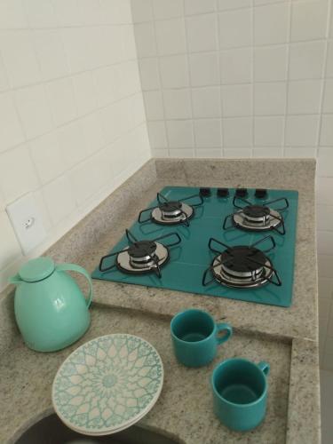 a stove top with a teapot and cups on a counter at Mar Turquesa Eco Pousada in Maragogi