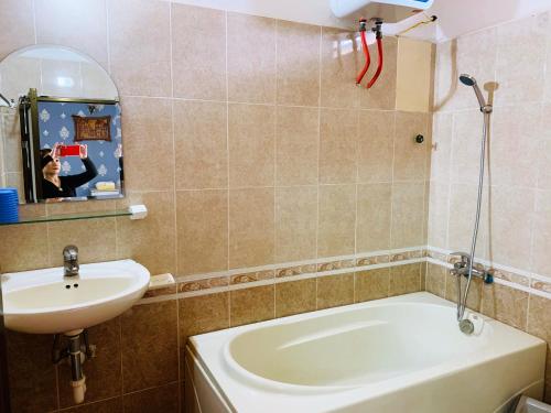 uma casa de banho com uma banheira, um lavatório e um espelho. em RẠNG ĐÔNG em Da Lat