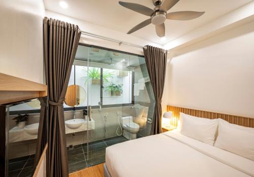 a bedroom with a bed and a bathroom at Ann Hotel & Spa Khem Beach PQ in Phú Quốc