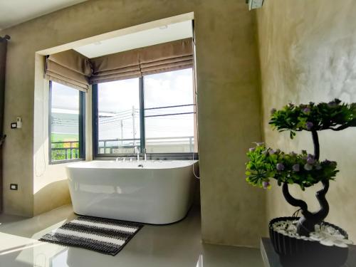 a bathroom with a large tub and a large window at Lounge in Loft HuaHin Pool Villa บ้านพักในหัวหิน in Ban Wang Bot