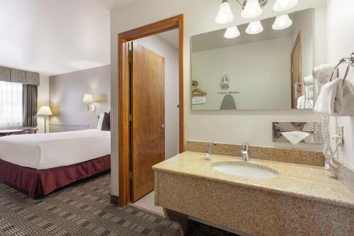 Habitación de hotel con lavabo y cama en Americas Best Value Inn Burns, en Burns