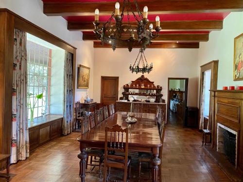 a dining room with a table and chairs and a chandelier at Casona Lo Aguirre , Hospedaje de Temporada Cálidas in Talagante