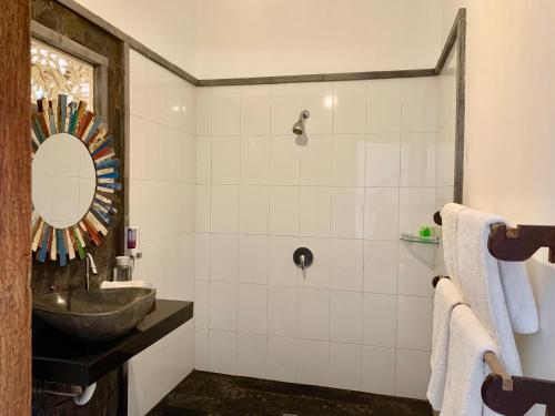a bathroom with a sink and a mirror at The Palms Ceningan Hotel in Nusa Lembongan