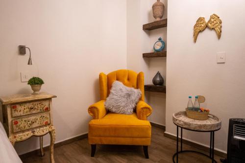 an orange chair in a room with a table at Villa Toscana ValQuirico Lofts & Suites Hotel Boutique in Santeagueda