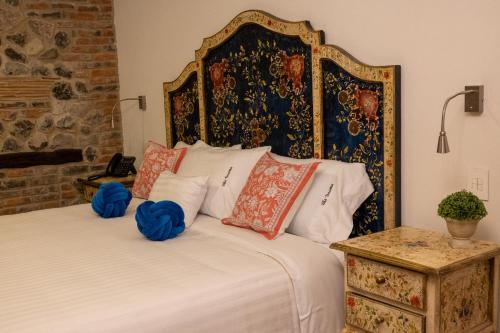 a bedroom with a large bed with red and blue pillows at Villa Toscana ValQuirico Lofts & Suites Hotel Boutique in Santeagueda
