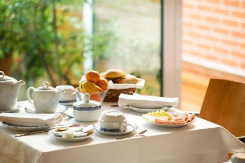 Una mesa con un mantel blanco con comida encima. en Costa Nova Hotel, en Costa Nova