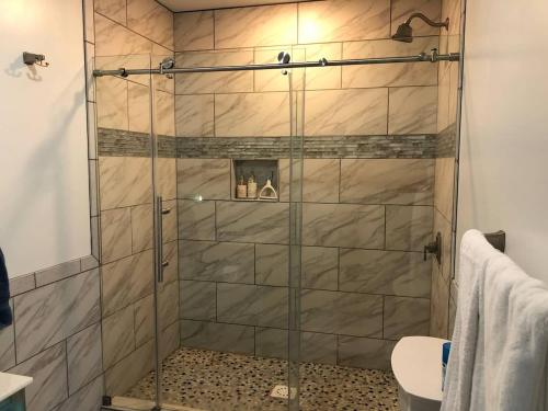 a shower with a glass door in a bathroom at 1st Class Rentals Cooperstown New 3 Bedroom House in Cooperstown
