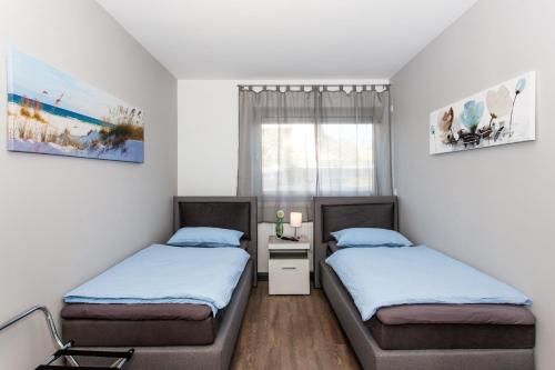 a bedroom with two beds and a window at Kaiser - Ferienwohnungen Dreiburgenblick in Patersberg