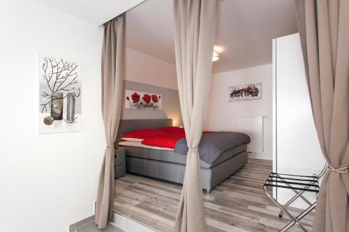 a bedroom with a bed with curtains in it at Kaiser - Ferienwohnungen Dreiburgenblick in Patersberg