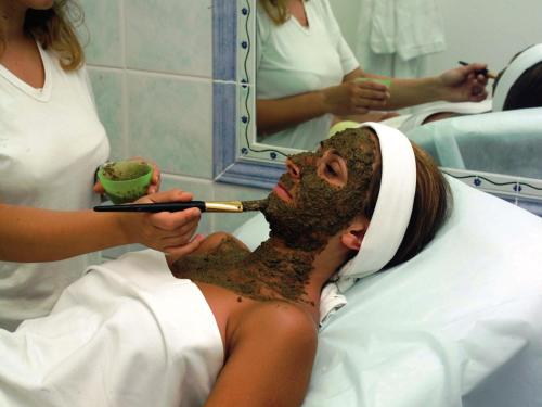 a woman in a hospital room brushing her teeth at Hotel Terme Park Imperial in Ischia
