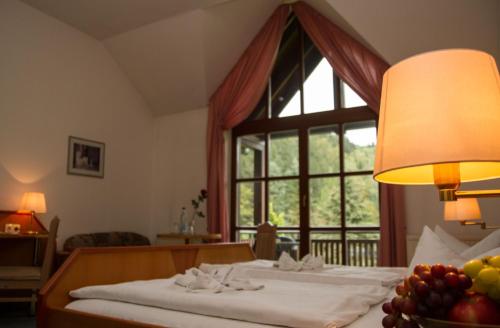 a bedroom with a bed with a window and a bowl of fruit at Hotel Schwarzbeerschänke Pobershau in Pobershau