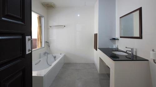 ウッタラディットにあるARAYA HOTELのバスルーム(シンク、バスタブ、鏡付)