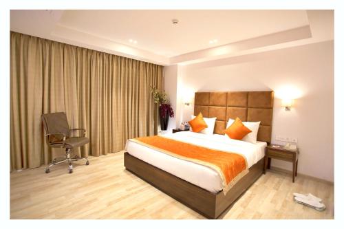 a hotel room with a bed and a desk and a chair at Hotel Hampi International in Hospet
