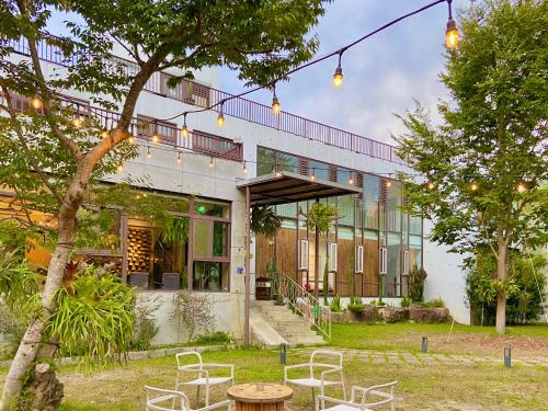 a building with chairs and a table in front of it at 愛黏在一起設計師民宿 Lovers BNB in Yuchi