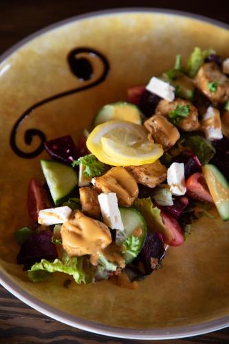 a plate of food with a salad in a bowl at Parsons Hilltop Safari Camp in Balule Game Reserve
