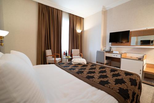 a hotel room with a bed and a desk at The Green Park Diyarbakir in Diyarbakır
