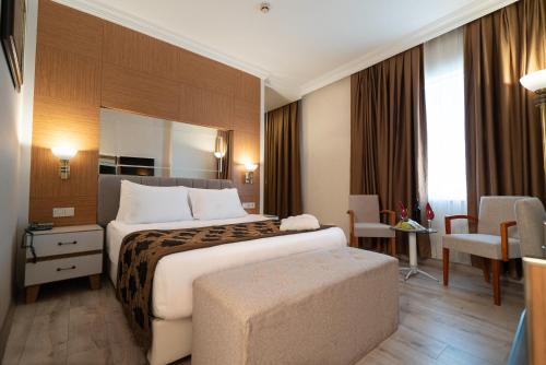 a hotel room with a large bed and a desk at The Green Park Diyarbakir in Diyarbakır