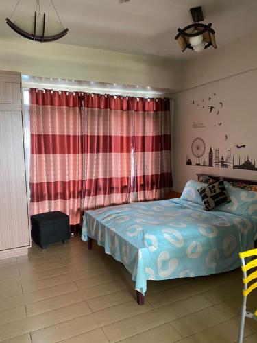 a bedroom with a bed and a red curtain at Favila Condotel Unit-150 Newport Boulevard near Airport Terminal 3 and all other Airport in Manila