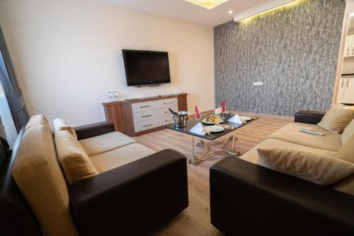 a living room with two couches and a tv at The Green Park Diyarbakir in Diyarbakır