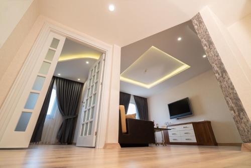 a living room with a mirror and a television at The Green Park Diyarbakir in Diyarbakır