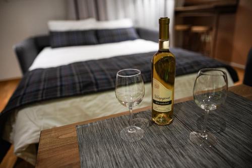 una botella de vino sentada en una mesa con dos copas de vino en FeelSTONE apartmani Brzeće en Brzeće