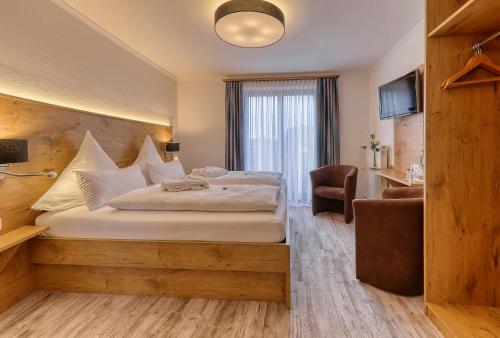 A bed or beds in a room at Hotel Waldfrieden "Das kleine Hotel"