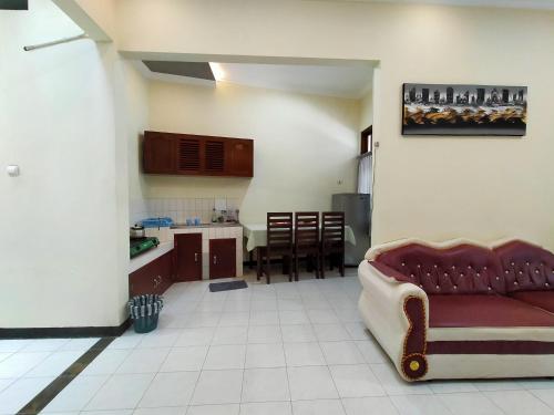 Il comprend un salon avec un canapé et une cuisine. dans l'établissement Abadi Homestay, à Yogyakarta
