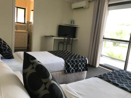 Postel nebo postele na pokoji v ubytování Coffs Shearwater Motel