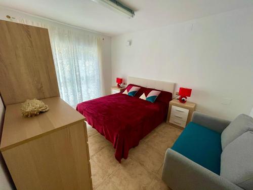 1 dormitorio con cama roja y sofá en Royal Beach House Vista Mar en La Mata