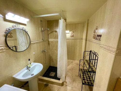 Un baño con lavabo y ducha con espejo. en Royal Beach House Vista Mar, en La Mata