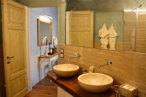 uma casa de banho com 2 lavatórios e um espelho grande em Il Mastio di Spedaletto em Pienza