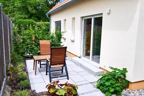 2 Stühle und ein Tisch auf der Terrasse in der Unterkunft Natur Apartments Natalia in Fürth