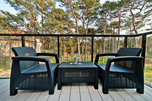 a patio table and chairs on a deck at BlueApart Verano Residence in Jurata