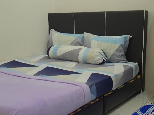a bed with a black headboard and pillows at Rest n Splash by Home Stay Cikgu D'Inapan Kijang in Alor Setar