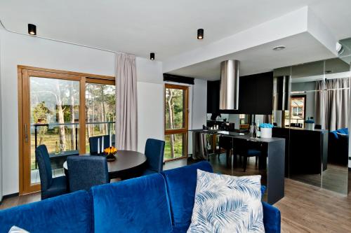 a living room with a blue couch and a dining room at BlueApart Verano Residence in Jurata