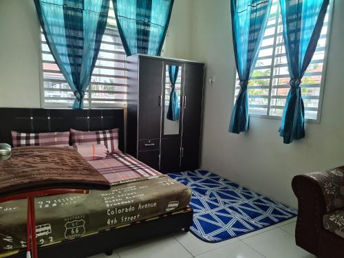a bedroom with a bed with blue drapes at Rest n Splash by Home Stay Cikgu D'Inapan Kijang in Alor Setar