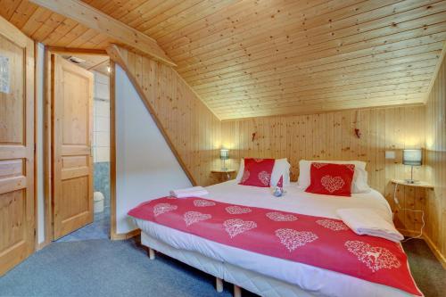 une chambre avec un grand lit avec des oreillers rouges dans l'établissement La Ruche 2, à Morzine