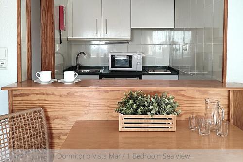 a kitchen with a table and a microwave at Apartamentos La Era Park in Benidorm