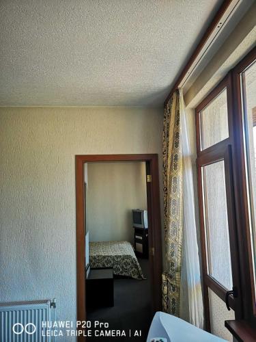 a bedroom with a mirror and a bed in it at Ribkata Family Hotel in Smolyan