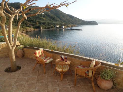 a patio with a table and chairs and a view of the water at Endless Blue in Ravdhoúkha