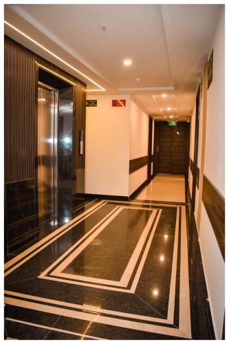 an elevator lobby with a black and white tile floor at THE DOWNTOWN in Kānpur