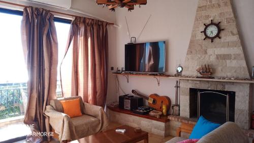 a living room with a fireplace and a tv at Marmari View in Marmarion