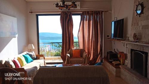 a living room with a large window and a couch at Marmari View in Marmarion