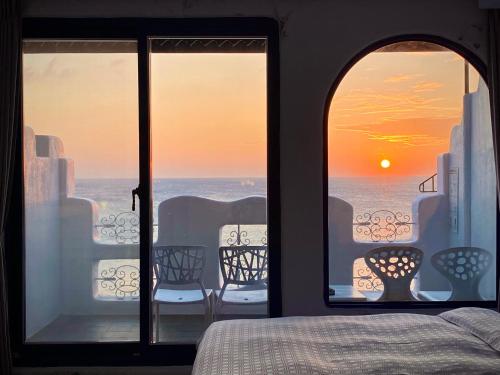 a bedroom with a view of the ocean from a window at Seyan Inn in Eluan