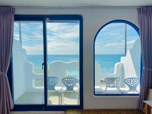 a room with a view of the ocean from a balcony at Seyan Inn in Eluan