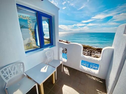 a balcony with a table and a view of the ocean at Seyan Inn in Eluan