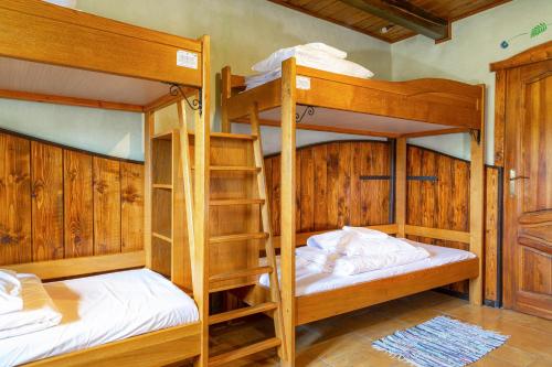 2 łóżka piętrowe w pokoju z drewnianymi ścianami w obiekcie Zajazd Przystocze - Bałtowski Kompleks Turystyczny w Bałtowie