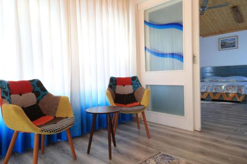 two chairs and a table in a room with a bed at StayVista at Dudly Manor with Swimming Pool in Dehradun