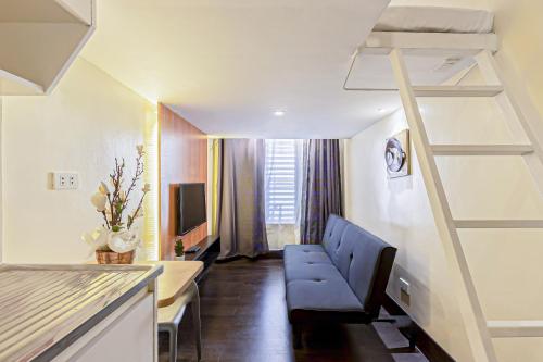 a room with a stair case and a room with a living room at Selah Lofts Hotel in Manila