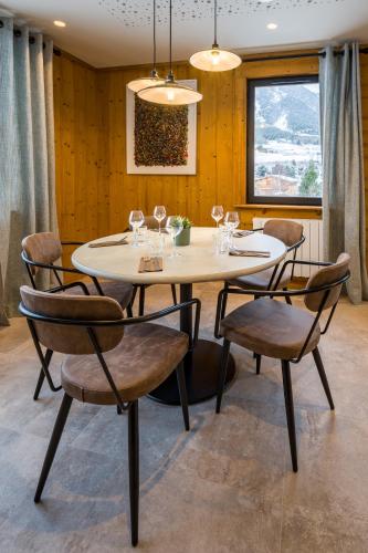 a dining room with a white table and chairs at L'Outa Hotel Restaurant in Termignon